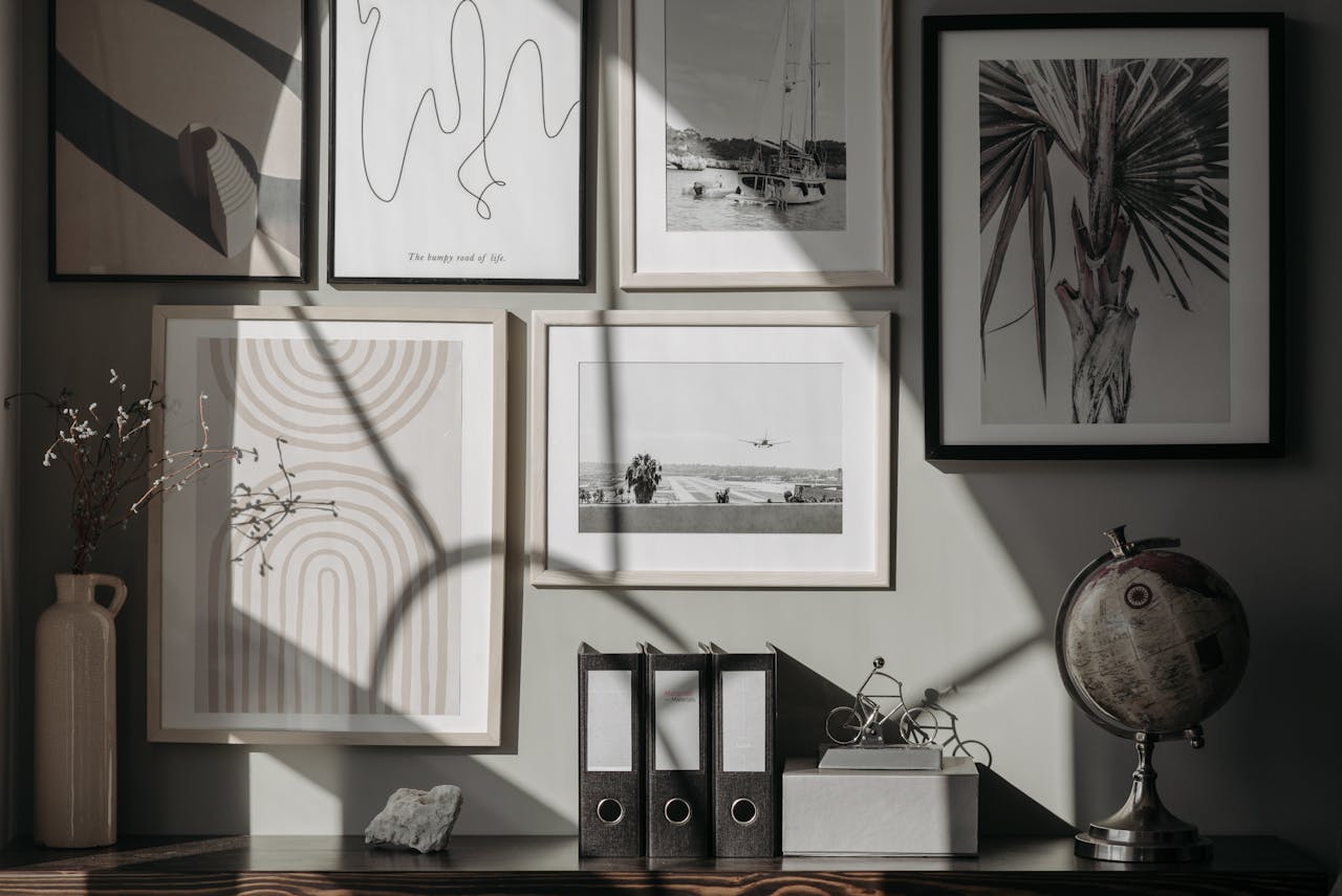 home-hero A stylish and modern interior featuring framed art prints, a globe, and decor items on a wooden surface.